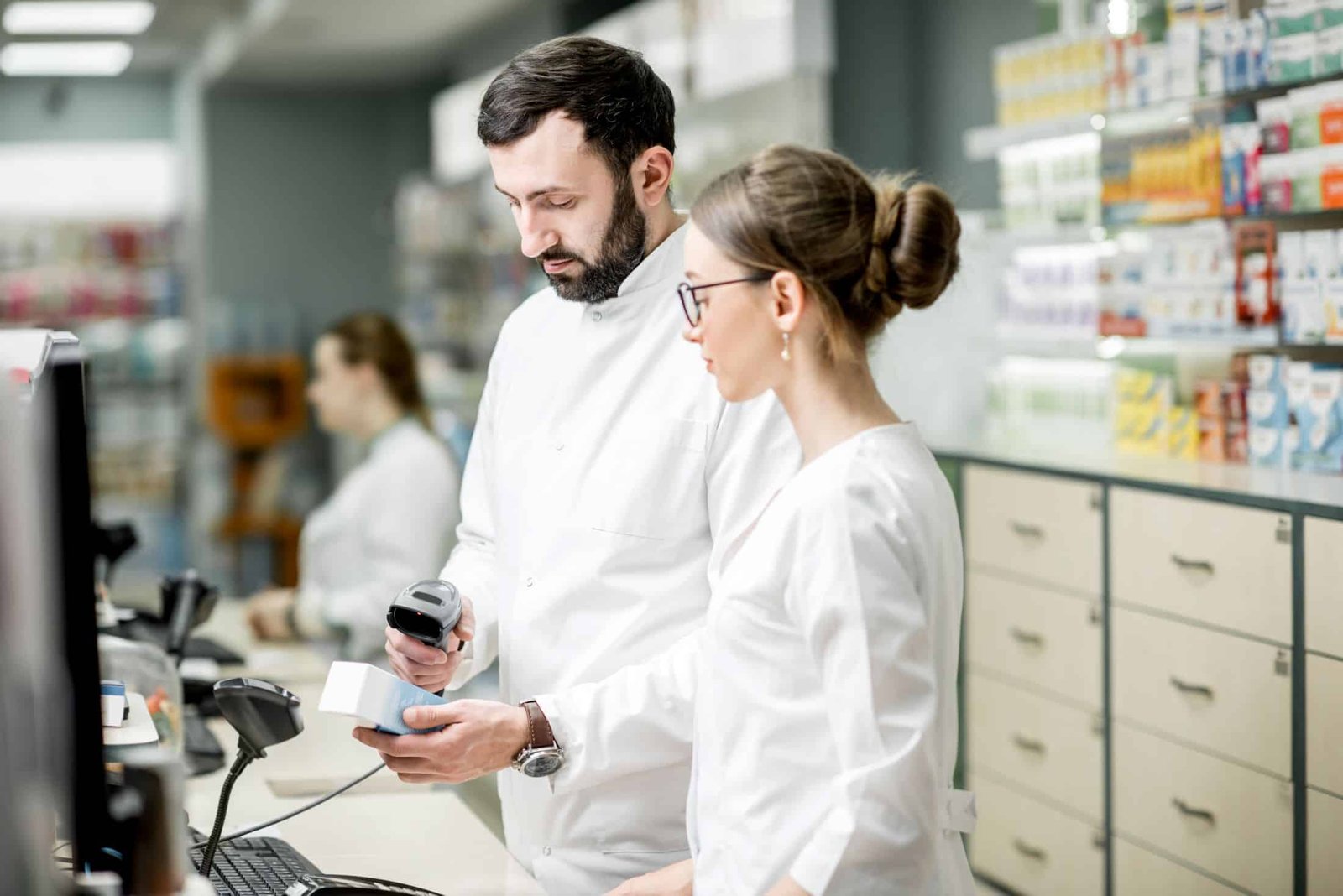 Zwei Apotheker prüfen eine Arzneimittelpackung in der Apotheke