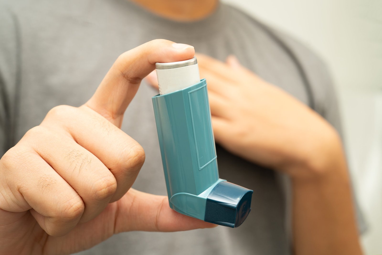 Person hält einen Inhalator vor dem Oberkörper